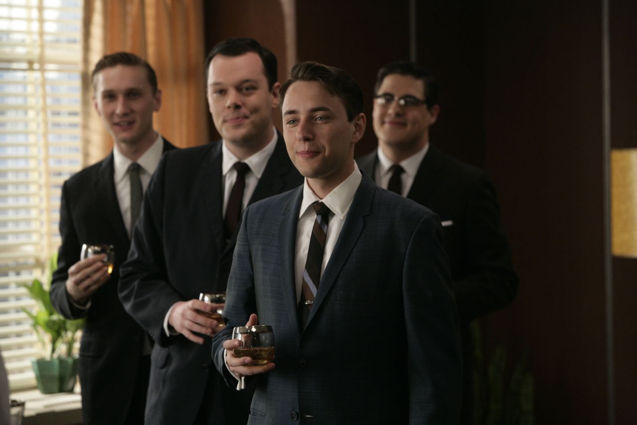 Wearing dark, formal suits was a nearly century-old tradition by the time "Mad Men" ad men donned identical looks -- with highballs -- at the Sterling Cooper agency in 1960. Their suits' slim silhouettes came from returning WWII soldiers' athletic figures, said University of Notre Dame history professor and author Linda Przybyszewski. Suits narrowed in the shoulders, torso and legs to fit the new physique.