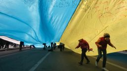Ukrainian kids play under a huge yellow-and-blue Ukrainian national flag at a rally in Kiev's Independent square, Ukraine, Saturday, April 5, 2014.