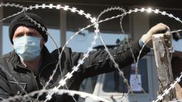 A pro-Russian militant wearing a surgical mask guards a barbed wire covered barricade in front of the Donetsk regional administration building on April 8, 2014.
