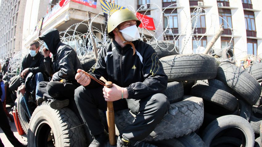 A pro-Russian militant holding a bat guards a barricade in front of the Donetsk regional administration building on April 8, 2014. Ukraine mounted a counteroffensive on April 8 by vowing to treat the separatists as "terrorists" and making 70 arrests in a nighttime security sweep, while hundreds of militants remained holed inside the Donetsk administration building a day after proclaiming the creation of an independent "people's republic" and demanding that an independence referendum be held before May 11.