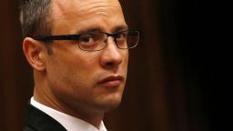 Paralympic track star Oscar Pistorius sits in the dock ahead of his trial for the murder of his girlfriend Reeva Steenkamp, at the North Gauteng High Court in Pretoria, on March 25, 2014.