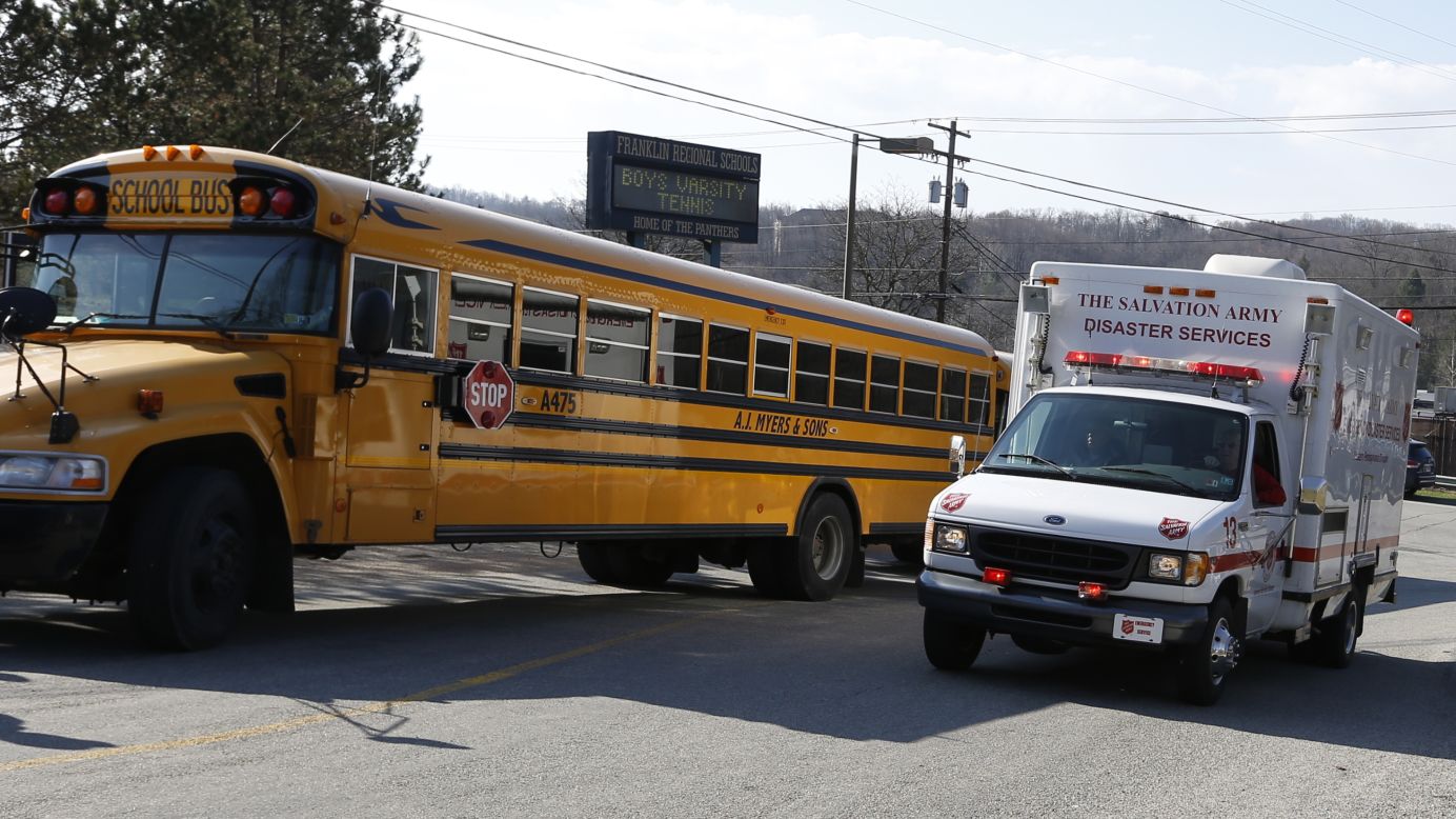 A Salvation Army disaster services vehicle drives past a school bus and onto the campus on April 9.