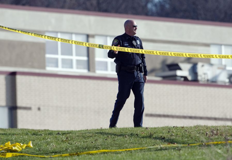 A police officer stands by the scene outside the high school on April 9. 