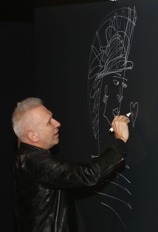 The French couturier Jean Paul Gaultier signs on the wall to launch of his exhibition.