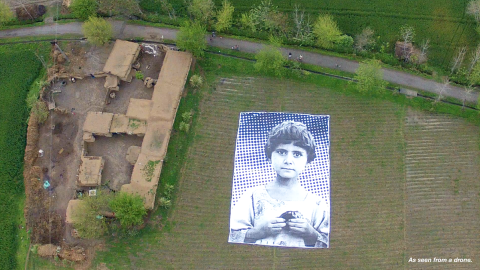 In a field in Pakistan, the face of a little girl stares into the sky, her gaze a haunting rebuke to the drones that killed her family in 2010. The name and location of the child is unknown.