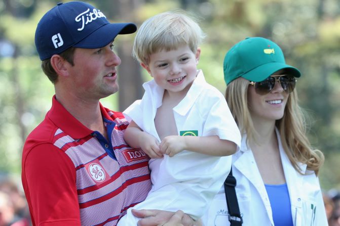 Webb Simpson , who won the U.S. Open in 2012, holds his son James as his wife Dowd looks on at the action.