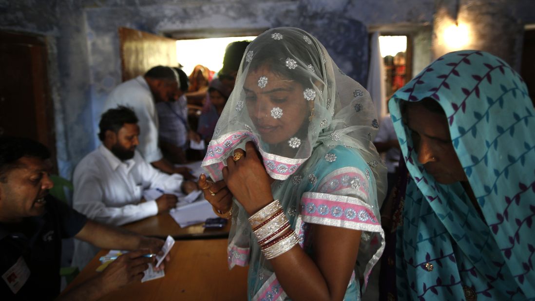 Voters wait for their identities to be verified before casting their ballots April 10 in Haryana, India.
