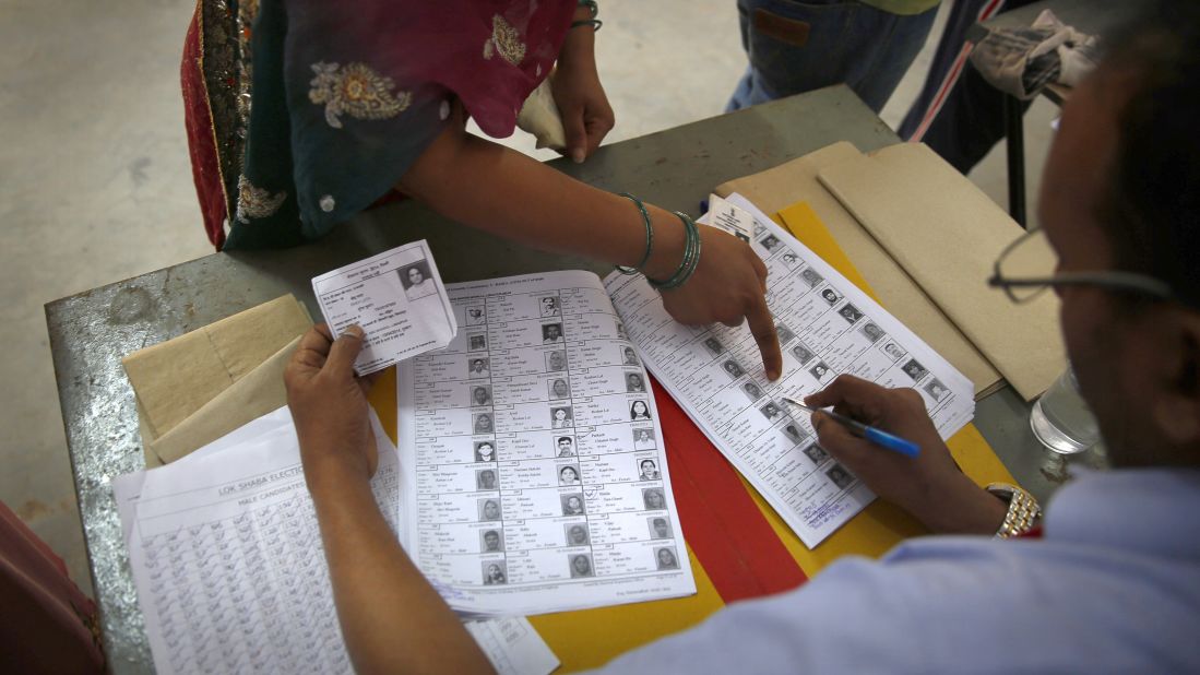 A woman points out her photo before casting her vote in New Delhi on April 10.