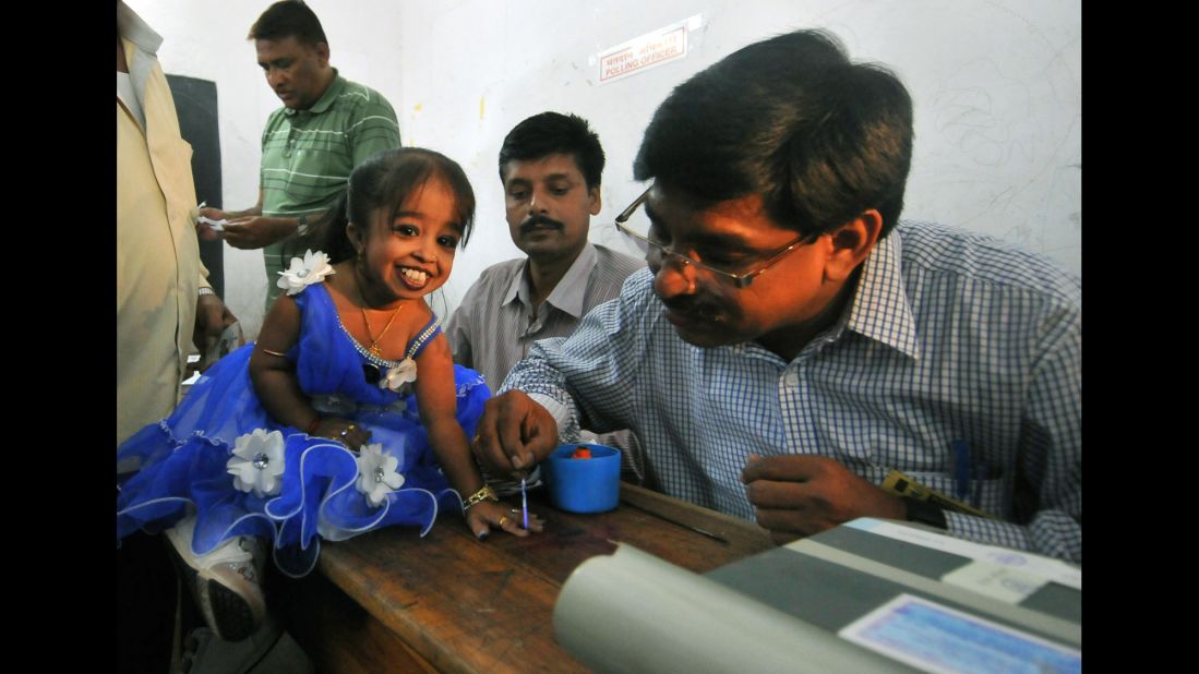 Jyoti Amge, a first-time voter and the world's shortest woman according to Guinness World Records, gets her finger marked with ink after voting in Nagpur, India, on April 10.