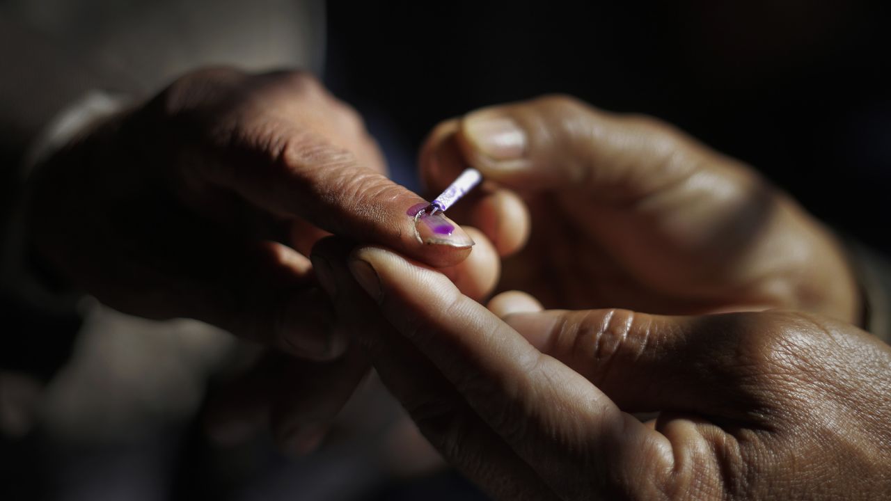 A polling official marks a voter's finger with ink in Senapati on April 9.