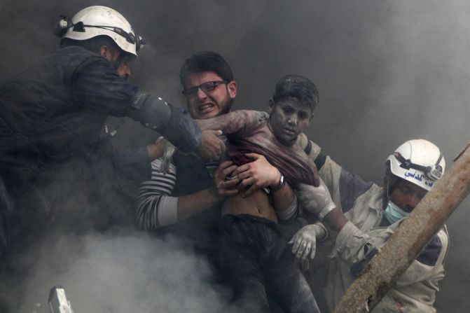 Men in Aleppo, Syria, pull a boy out of rubble Sunday, April 6, after what activists say was a bombing carried out by forces loyal to Syrian President Bashar al-Assad.
