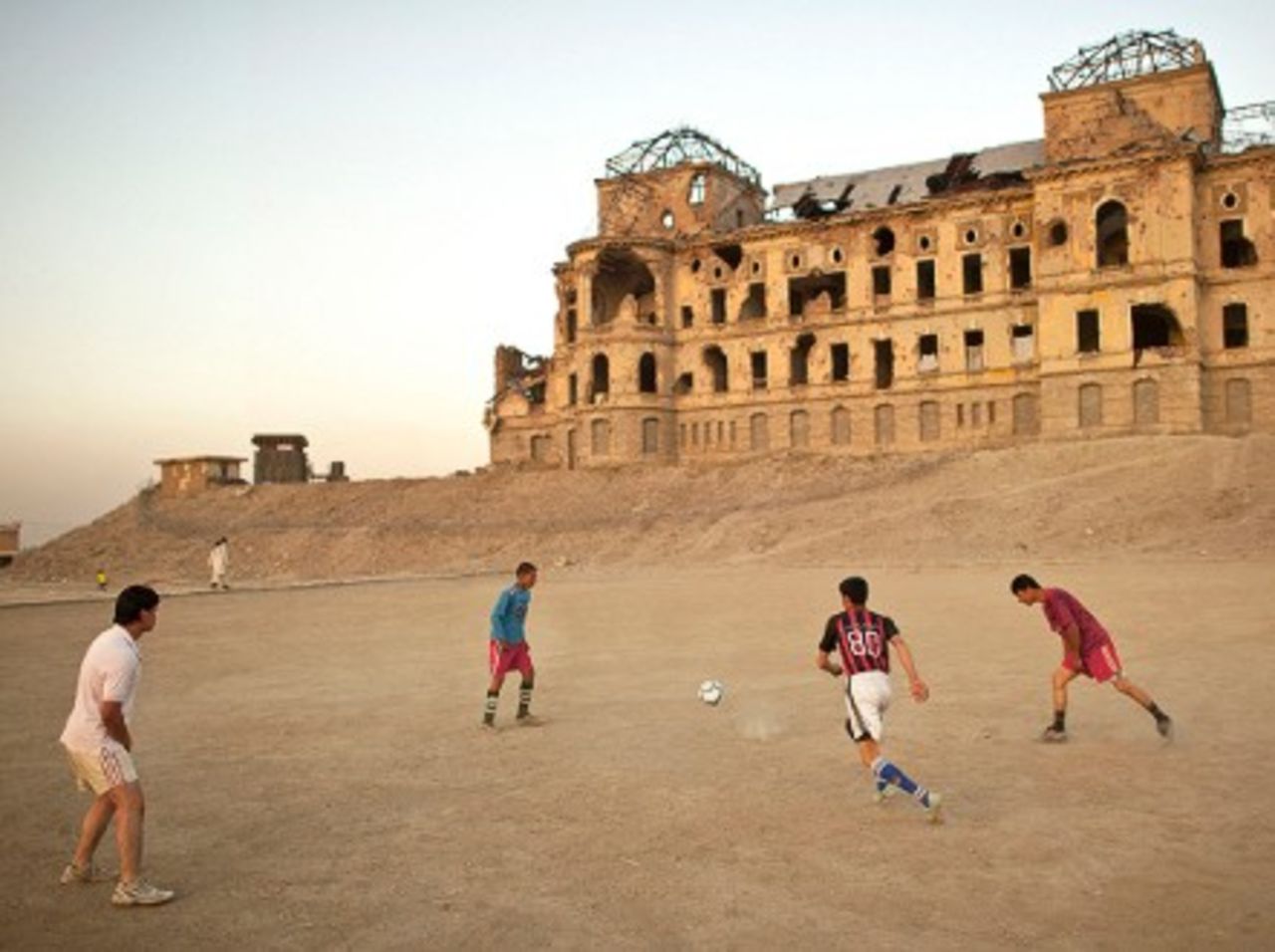Afghans play football outside the ruins of Darulaman Palace. - (Kate Brooks)