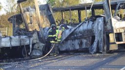 Firefighters hose down the wreckage of a bus and a semitruck that collided, Thursday, April 10, 2014, just north of Orland, Calif., that left at least nine dead. Authorities said it is not yet clear what caused the crash but that it involved a tour bus, a FedEx truck and a Nissan Altima. (AP Photo/The Chico Enterprise-Record, Dan Reidel)