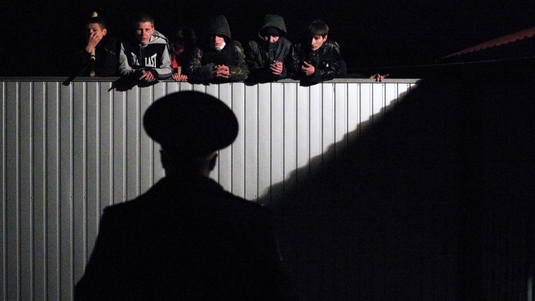 Pro-Russian young men look over the fence of a military recruitment office in Donetsk on Thursday, April 10.