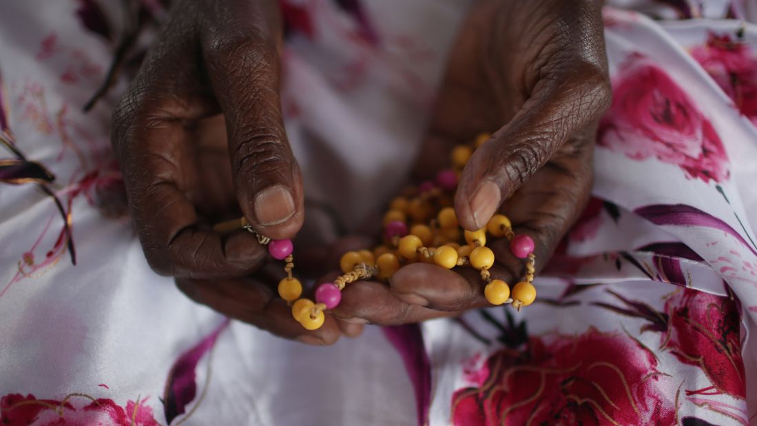 Ophelia Nyiramagumeri holds a rosary in Kigali. It was given to her by her nephew, who was killed in the 1994 genocide.