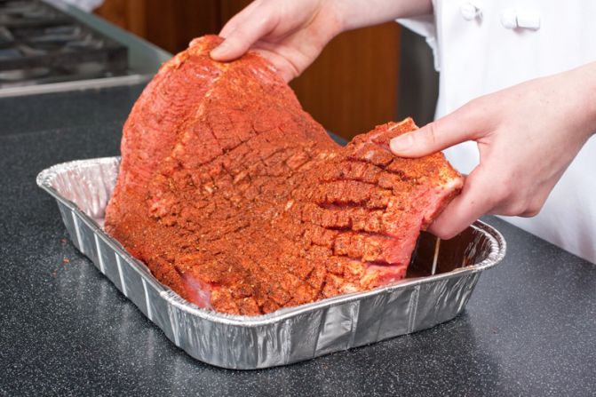 SET IN PAN: Blot the brisket dry and place it in a disposable pan.<br />WHY? A dry brisket forms a better crust. The pan keeps the brisket from burning while letting it develop char and absorb smoke. And it catches the juices for the sauce.<br />