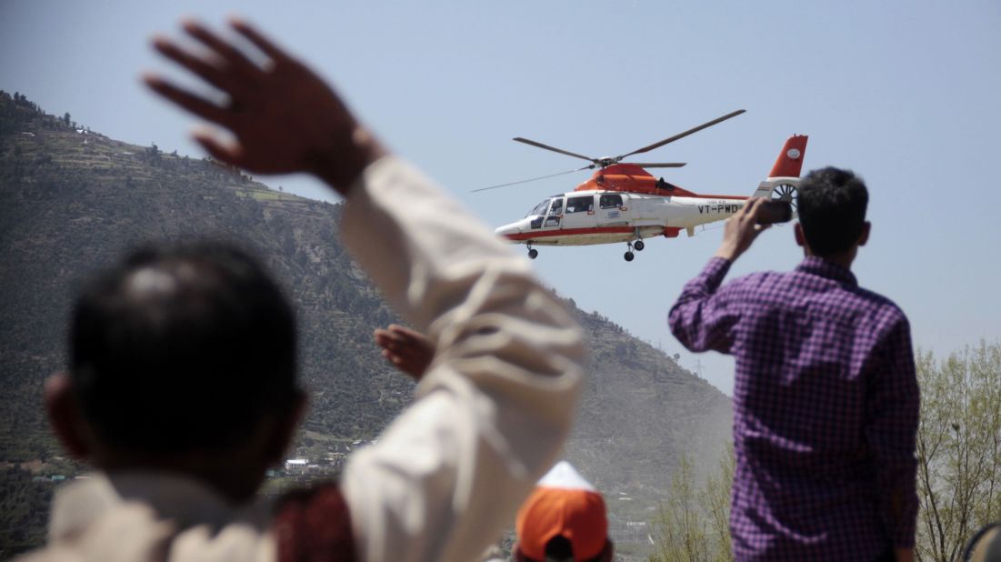 People in Doda wave as a helicopter carrying Gandhi leaves after a campaign rally on April 11.