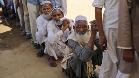 Indian Muslims wait outside a polling booth to cast their votes on Thursday, April 10.