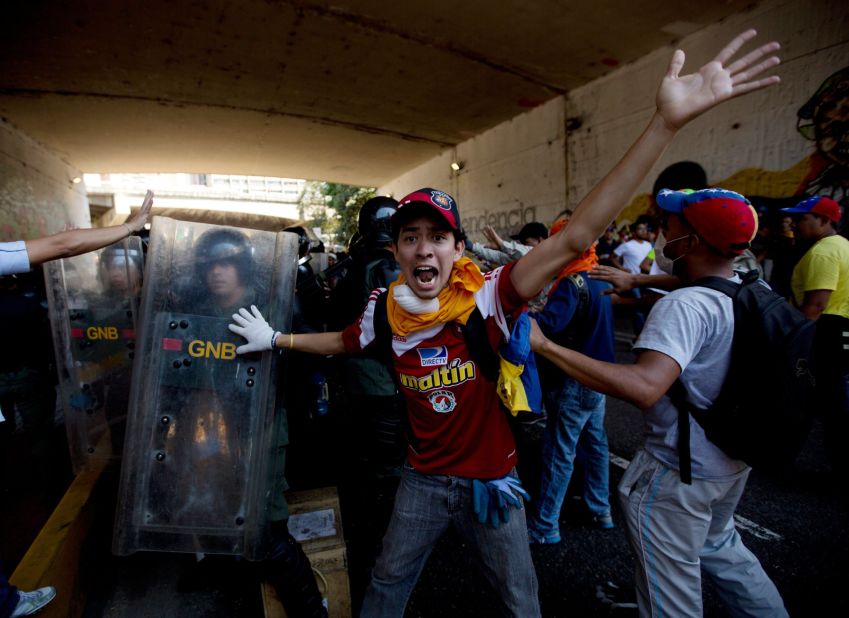 A protester shouts for fellow demonstrators to not attack the National Police trapped under a highway with protesters during clashes on April 12.