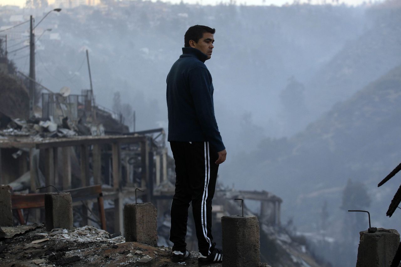 A man looks at the charred remains of homes in Valparaiso on April 13.