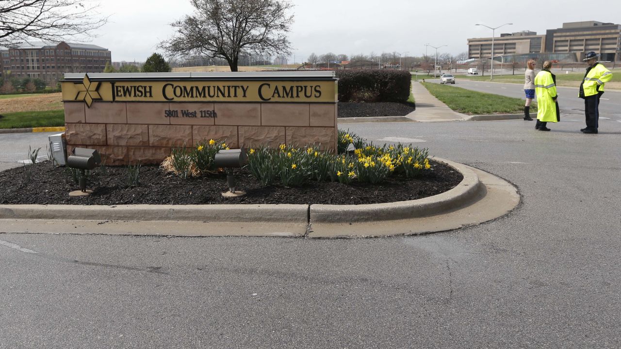 An Overland Park police officer and Kansas State Trooper guard the entrance of the Jewish Community Center after a shooting in Overland Park, Kansas, Sunday, April 13.