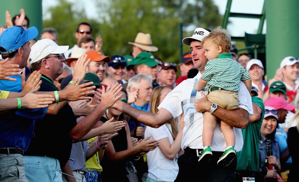 An emotional Watson holds his son, Caleb, as he celebrates with fans by the 18th green at Augusta.