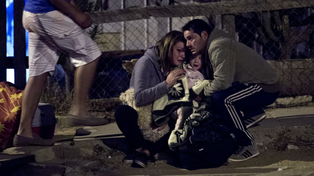 A family huddles in a street in Valparaiso as the city is evacuated April 13.