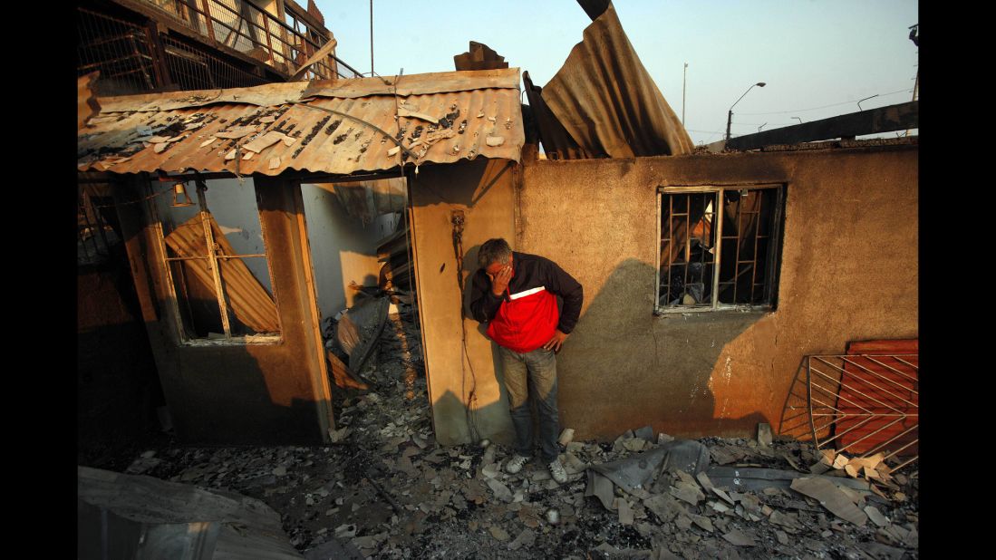 A man cries next to the remains of his house in Valparaiso.