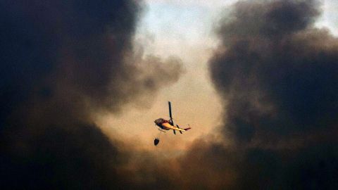 A helicopter flies over Valparaiso during efforts to quell the flames on April 13.