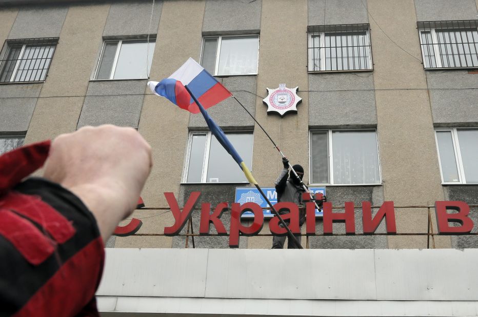 A man places a Russian flag over a police station after storming the building in Horlivka on April 14.