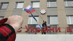 A pro-Russian man places a Russian flag over a police station during its mass storming in the eastern Ukrainian town of Horlivka on Monday, April 14, 2014.  The text reads: Ukrainian police station in Horlivka". Several government buildings has fallen to mobs of Moscow loyalists in recent days as unrest spreads across the east of the country.  (AP Photo/Efrem Lukatsky)