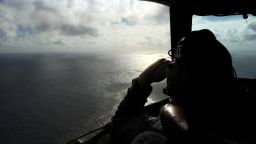 A member of the Royal New Zealand Air Force looks out of a window while searching for debris from the missing Malaysia Airlines Flight 370 over the Indian Ocean off the coast of western Australia on Sunday, April 13.