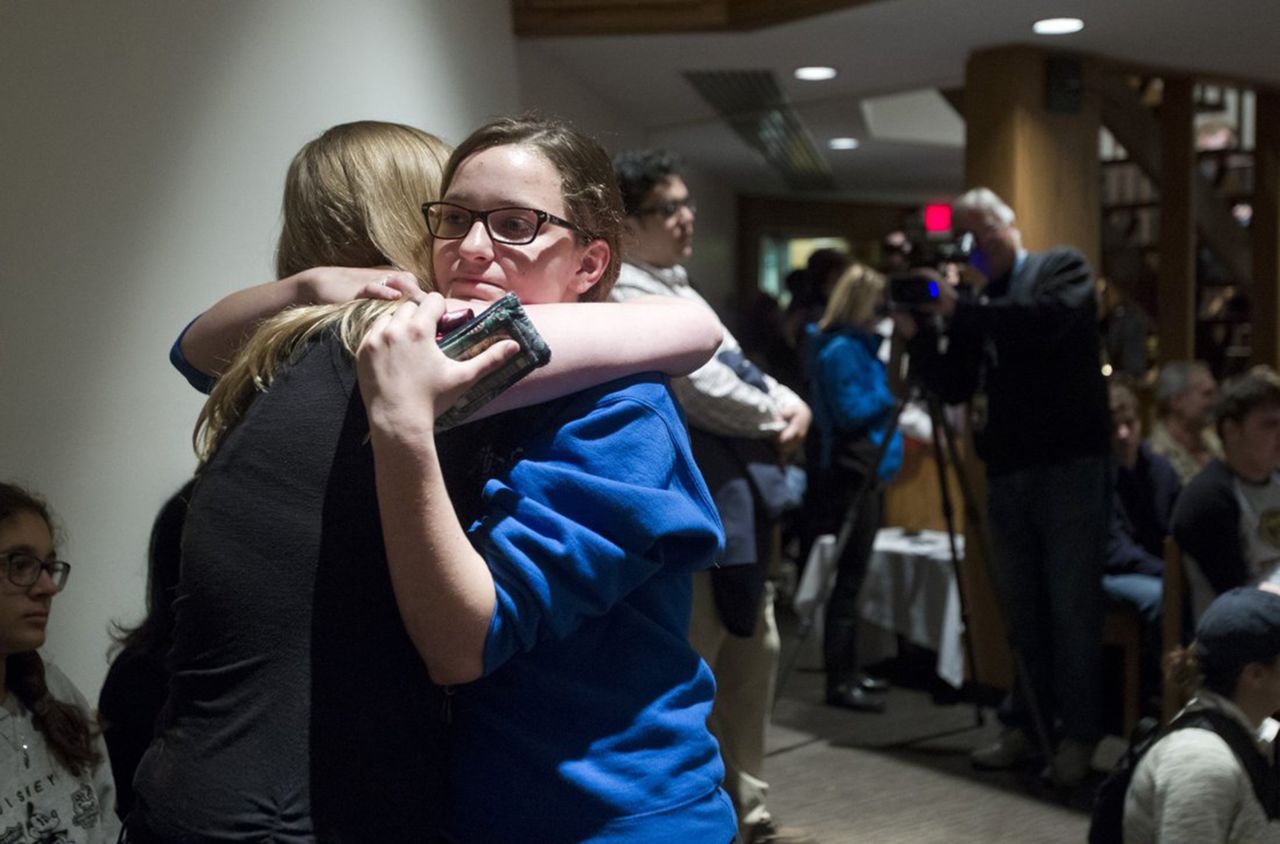 Rachel Trout, 16, receives a hug from a friend after addressing the crowd at St. Thomas the Apostle.