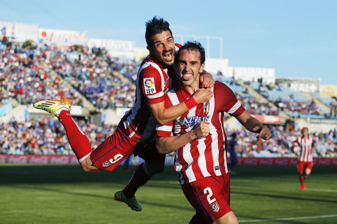 Atletico Madrid forward David Villa jumps on teammate Diego Godin after Godin's goal Sunday, April 13, in a Spanish league soccer game versus Getafe. Atletico won the game 2-0 to stay atop the league. 