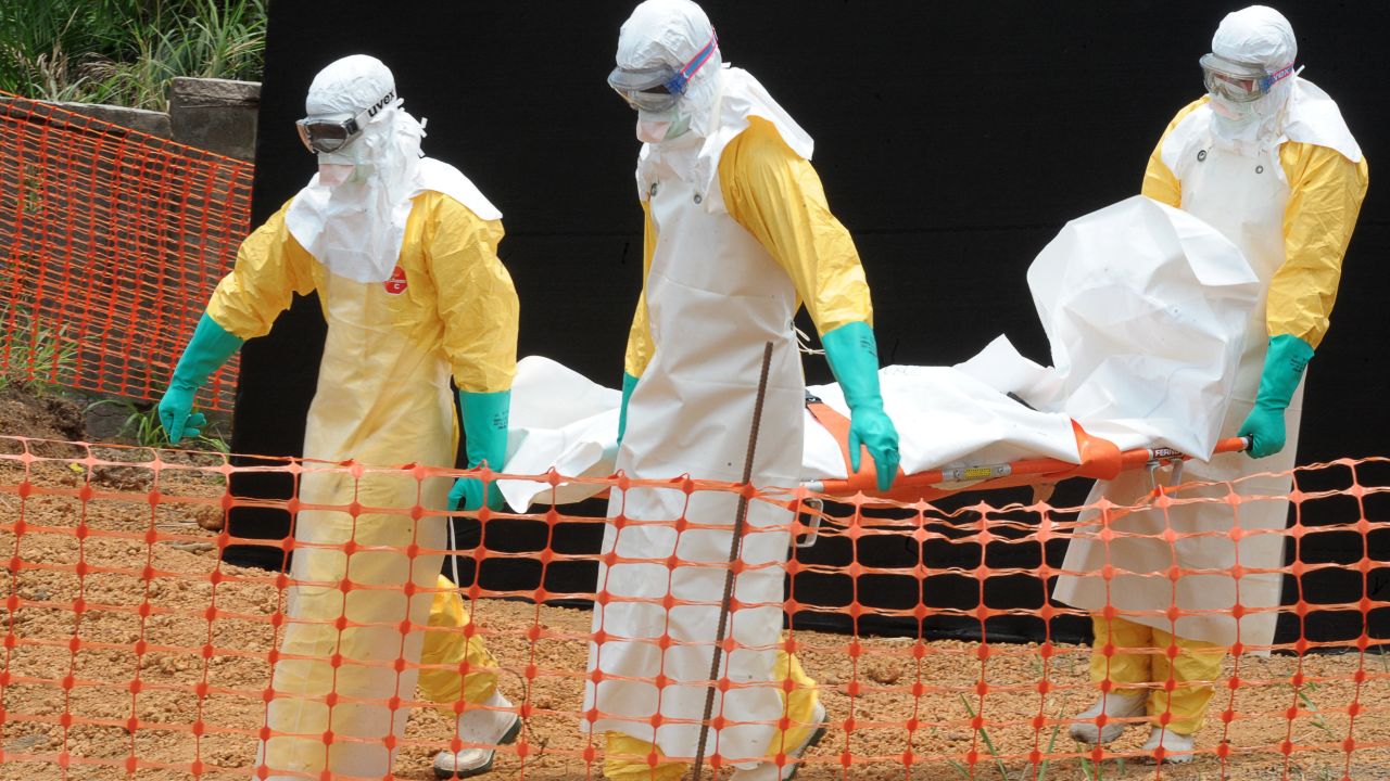Staff of the 'Doctors without Borders' ('Medecin sans frontieres') medical aid organisation carry the body of a person killed by viral haemorrhagic fever, at a center for victims of the Ebola virus in Guekedou, on April 1, 2014. 