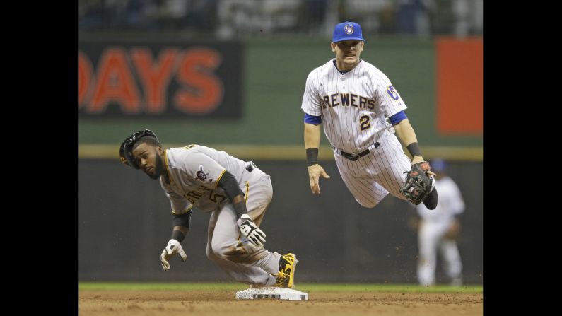 Milwaukee's Scooter Gennett, right, hangs in the air Saturday, April 12, after throwing to first base to complete a double play against Pittsburgh. Milwaukee won the game 3-2 for their eighth straight victory. <a href="http://www.cnn.com/2014/04/08/worldsport/gallery/what-a-shot-0408/index.html">See 33 amazing sports photos from last week</a>