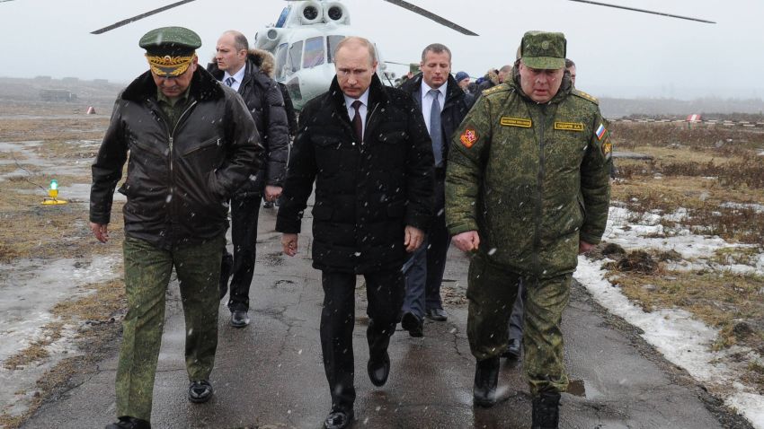Russia's President Vladimir Putin (front C) and Defence Minister Sergei Shoigu (front L) walk to watch military exercises upon his arrival at the Kirillovsky firing ground in the Leningrad region, on March 3, 2014.