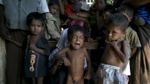 Rohingya children displaced by violence wait for medical care at a camp in Rakhine.