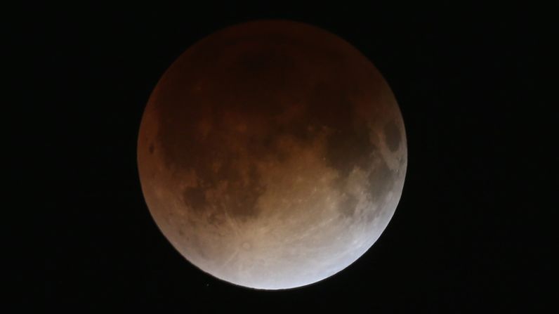 The red hue is caused by refracted sunlight in the Earth's atmosphere, which bounces off the moon while in shadow. The entire reddening process takes about an hour.
