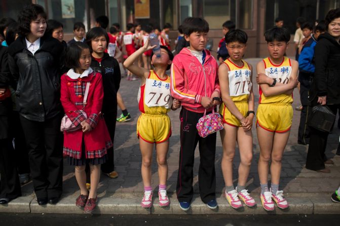 Young North Korean runners rest after finishing their part of the race.