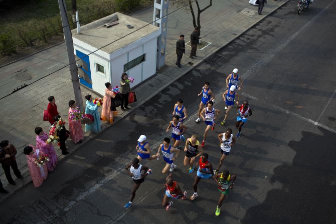 The lead pack of runners are cheered on by spectators at the roadside in central Pyongyang.