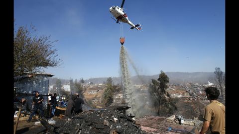 A helicopter releases water over Ramaditas Hill in Valparaiso on Monday, April 14.