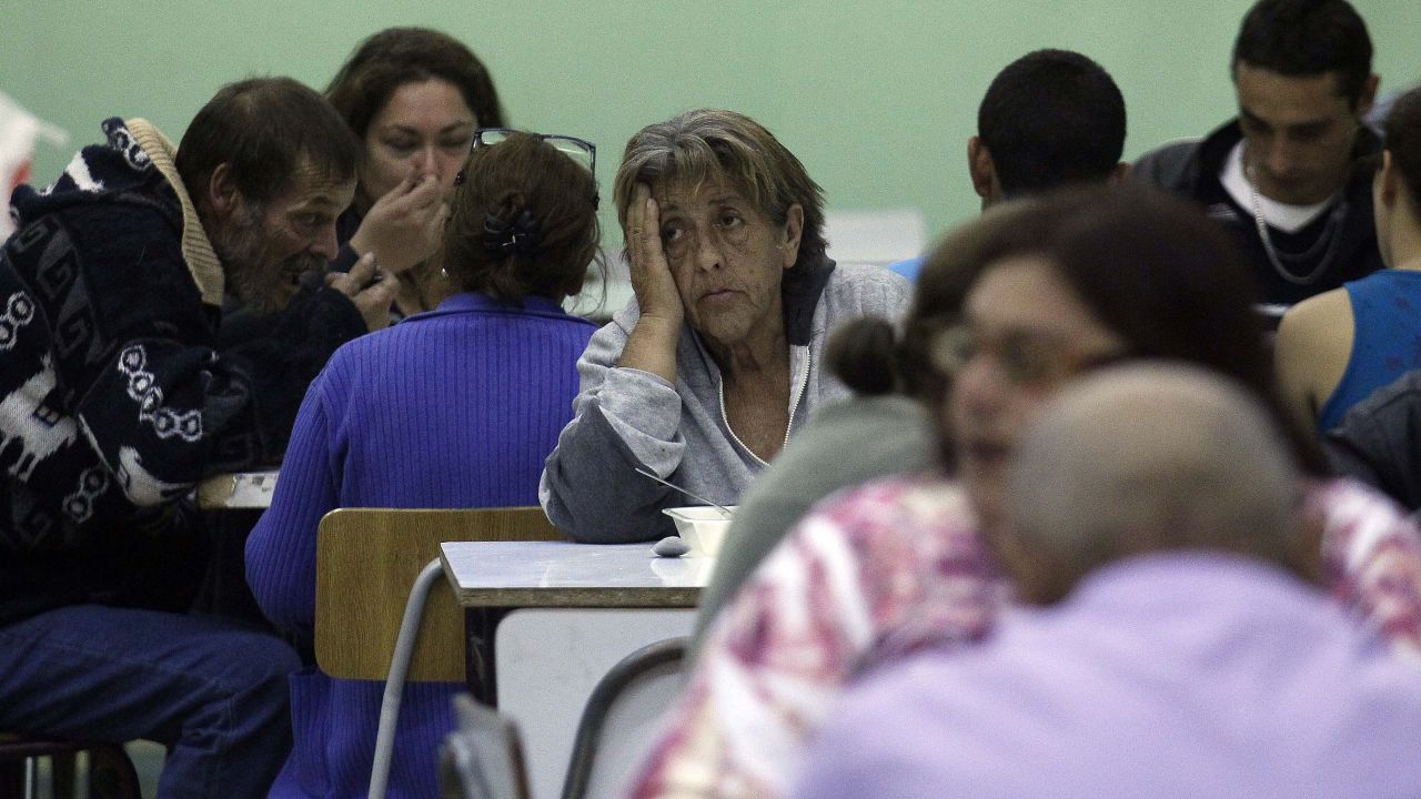 A woman waits for news April 14 at a shelter for fire victims.