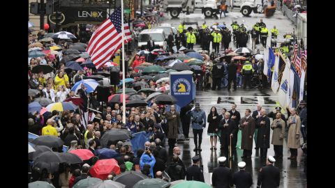 People pause Tuesday, April 15, as the American flag is raised at the finish line of the Boston Marathon, where two homemade bombs went off one year ago. It was the deadliest terrorist attack in the United States since 9/11.