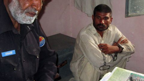 Mohammad Arif Ali (right) sits next to an officer at a police station in Punjab's Bhakkar district on April 14, 2014.