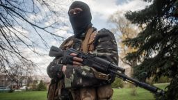A masked gunman stands guard near tanks in Slaviansk, Ukraine, on Wednesday, April 16.