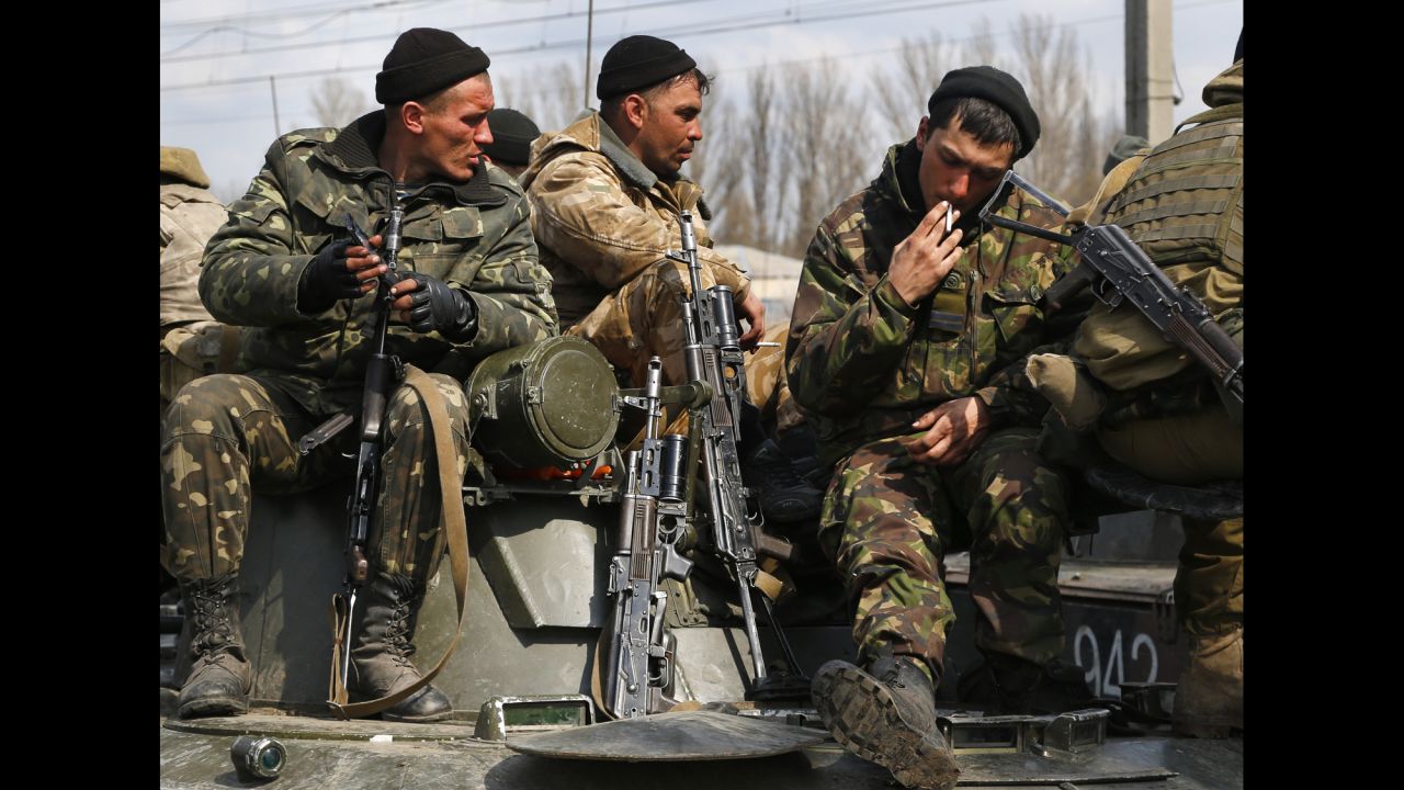 Ukrainian soldiers sit atop combat vehicles on their way to Kramatorsk.