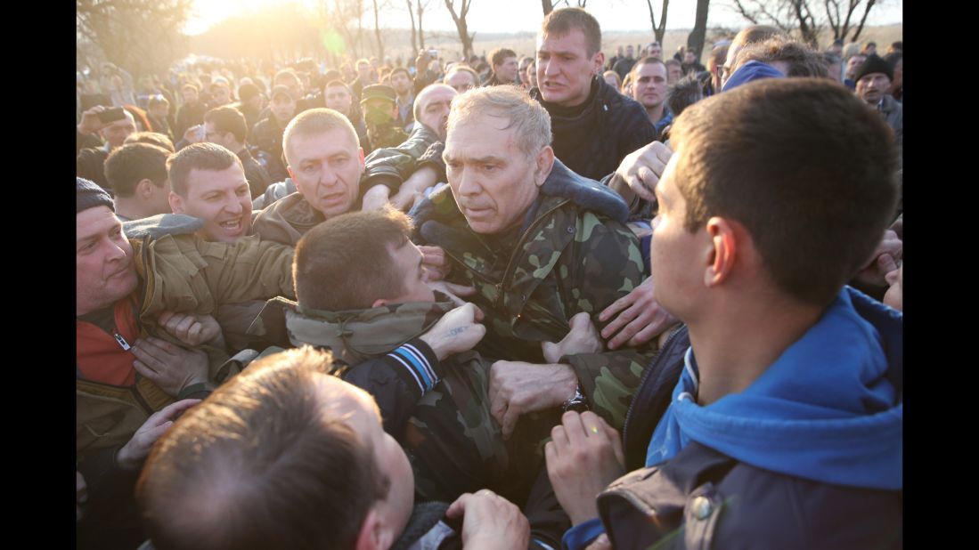 Ukrainian Gen. Vasily Krutov is surrounded by protesters after addressing the crowd outside an airfield in Kramatorsk on Tuesday, April 15.