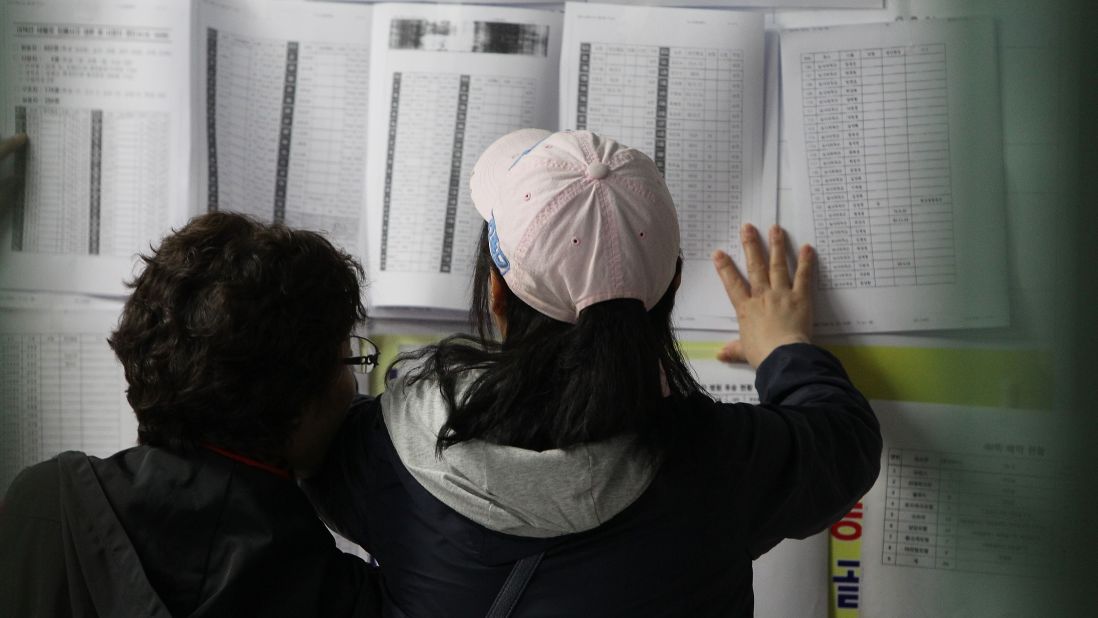 Relatives check a list of survivors April 16 in Jindo.