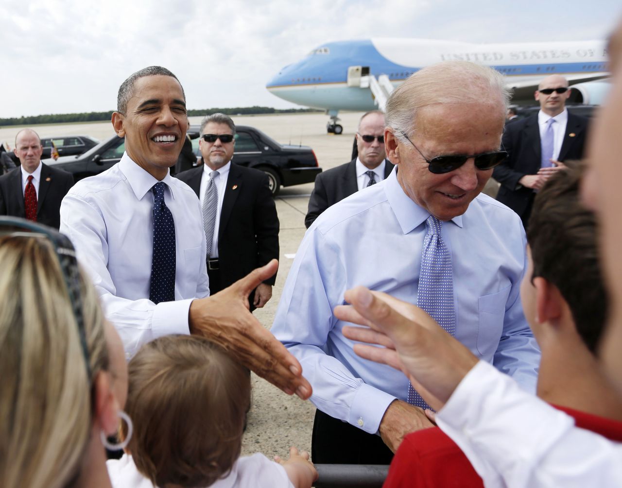 Obama and Biden greet supporters on the tarmac after arriving in Portsmouth, New Hampshire, in September 2012.